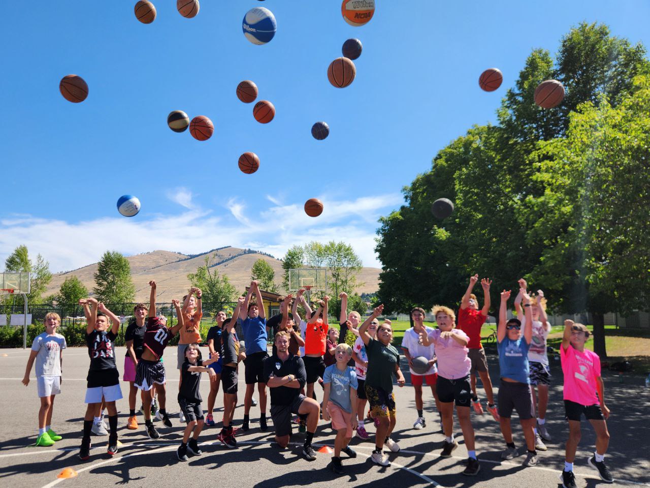 Rising Lion basketball players tossing basketballs into the air together